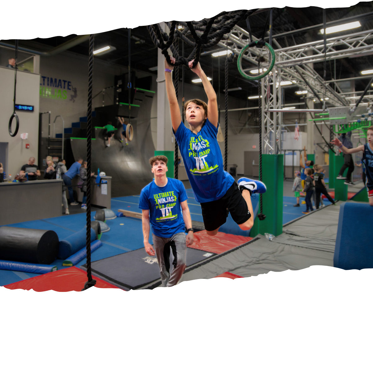Young Ninja Tackles Obstacles with Help of Instructor
